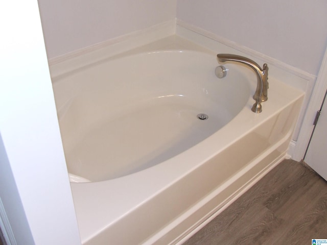 bathroom featuring a tub to relax in and hardwood / wood-style flooring