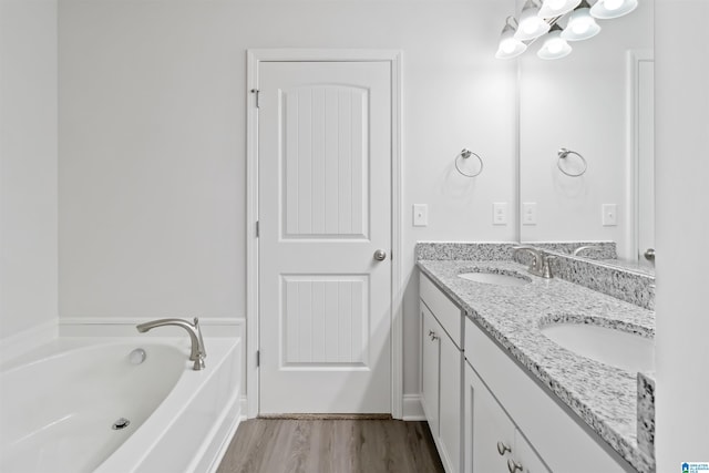 bathroom with hardwood / wood-style floors, dual bowl vanity, and a bathtub