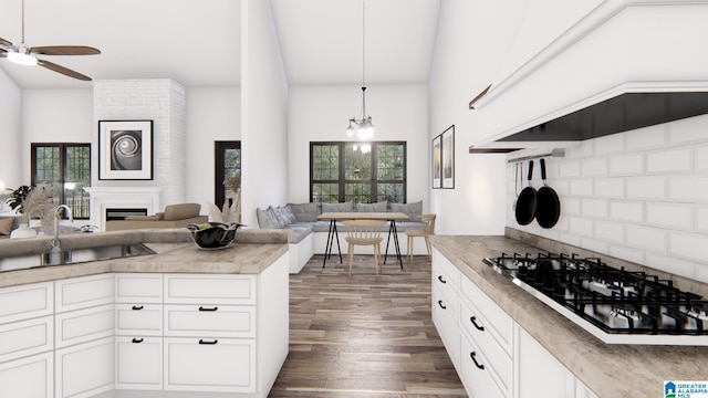 kitchen with gas cooktop, dark hardwood / wood-style flooring, custom exhaust hood, sink, and white cabinetry