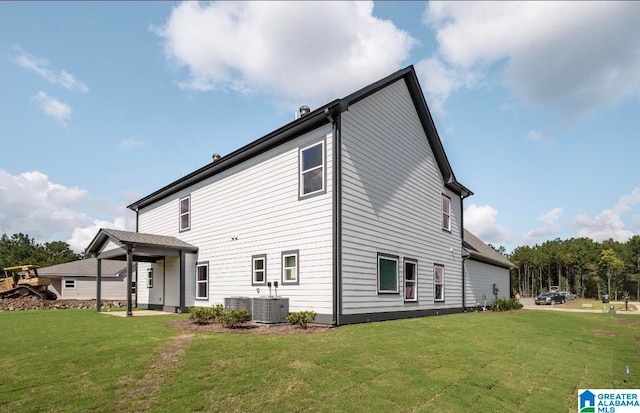 back of house with cooling unit and a yard