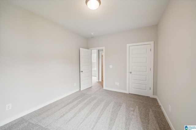 unfurnished room featuring light carpet