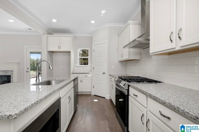 kitchen with stainless steel appliances, wall chimney exhaust hood, dark hardwood / wood-style flooring, crown molding, and sink