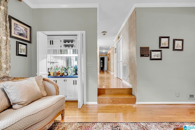 entrance foyer with ornamental molding and light hardwood / wood-style floors