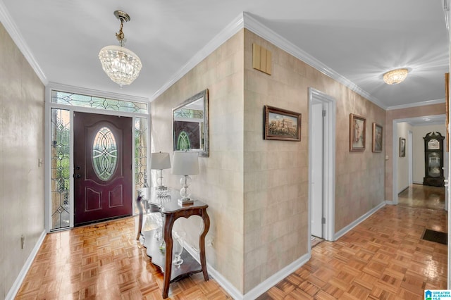 foyer entrance with light parquet floors, ornamental molding, tile walls, and a chandelier