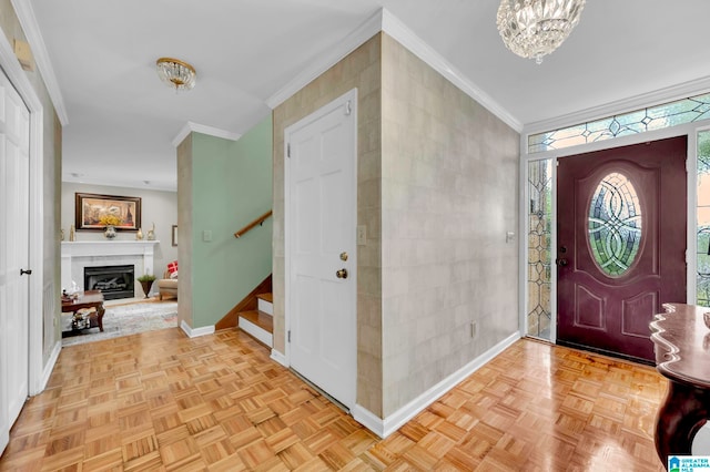 entrance foyer featuring light parquet flooring, a chandelier, and crown molding