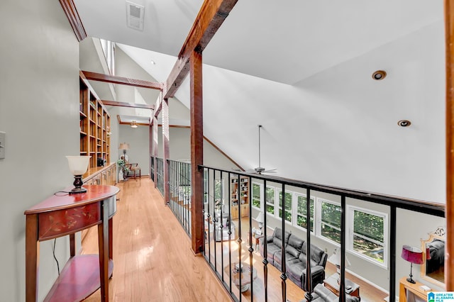 hall featuring light hardwood / wood-style flooring, beamed ceiling, and high vaulted ceiling