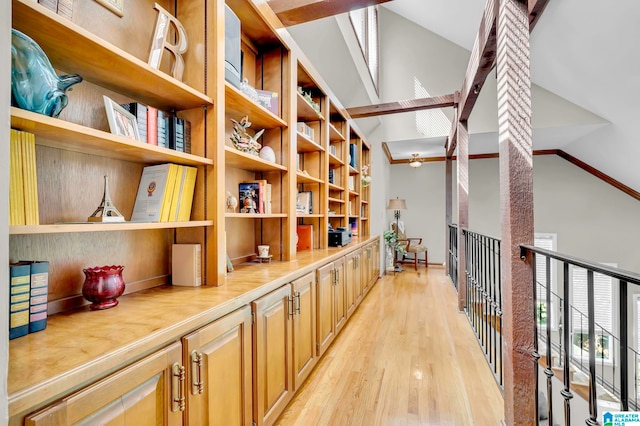 hallway with lofted ceiling and light hardwood / wood-style flooring