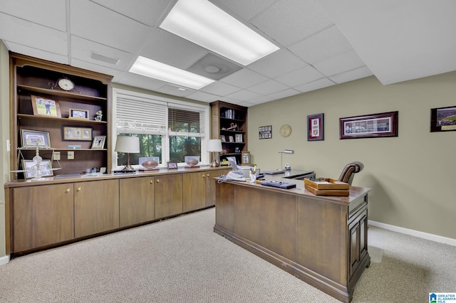 carpeted office space with a paneled ceiling