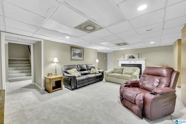 carpeted living room with a paneled ceiling