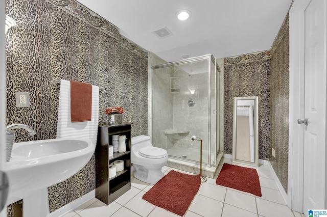 bathroom featuring toilet, sink, a shower with shower door, and tile flooring