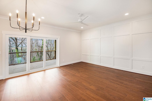 empty room featuring dark wood-type flooring, crown molding, and ceiling fan with notable chandelier