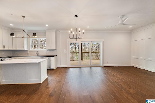 kitchen with sink, decorative light fixtures, white cabinets, and backsplash