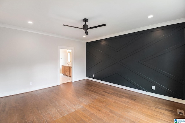 spare room with hardwood / wood-style flooring, crown molding, and ceiling fan