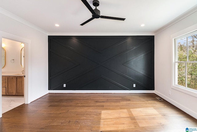 spare room featuring crown molding, ceiling fan, sink, and hardwood / wood-style floors