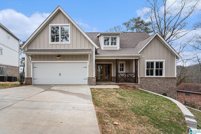 craftsman house with central AC, a porch, a garage, and a front lawn