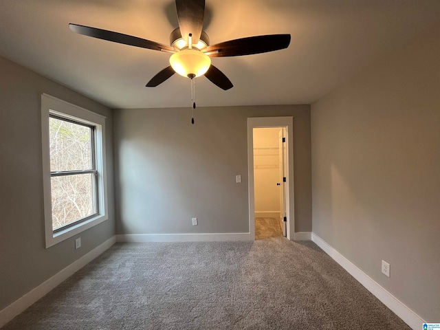 unfurnished room featuring ceiling fan and carpet