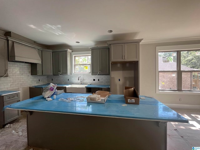 kitchen with custom range hood, sink, backsplash, and light tile floors