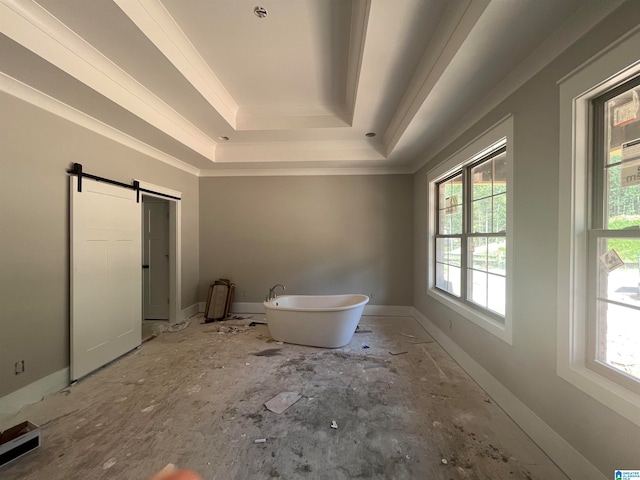 unfurnished bedroom with a barn door, a raised ceiling, multiple windows, and crown molding