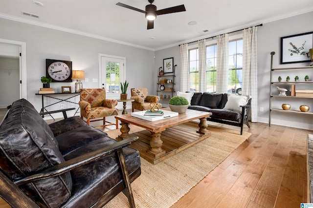 living room featuring ceiling fan, light hardwood / wood-style floors, and crown molding