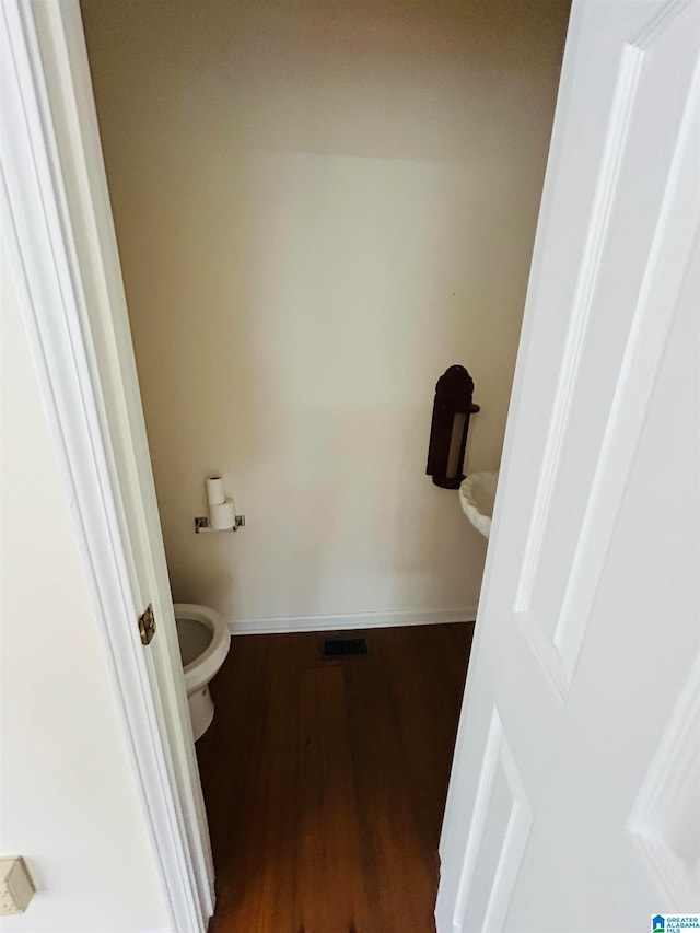 bathroom with toilet and wood-type flooring