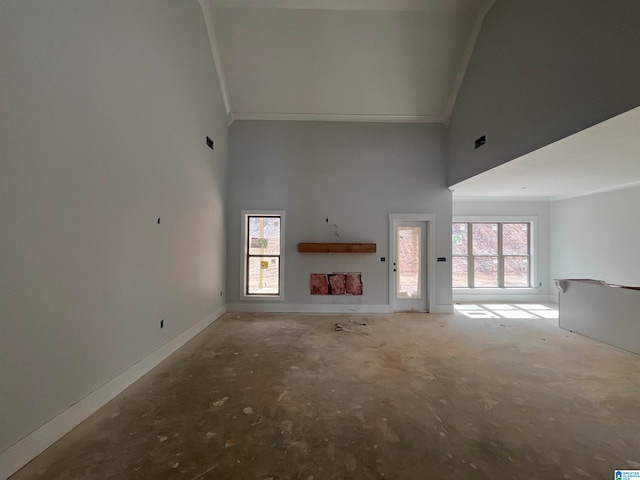 unfurnished living room with high vaulted ceiling