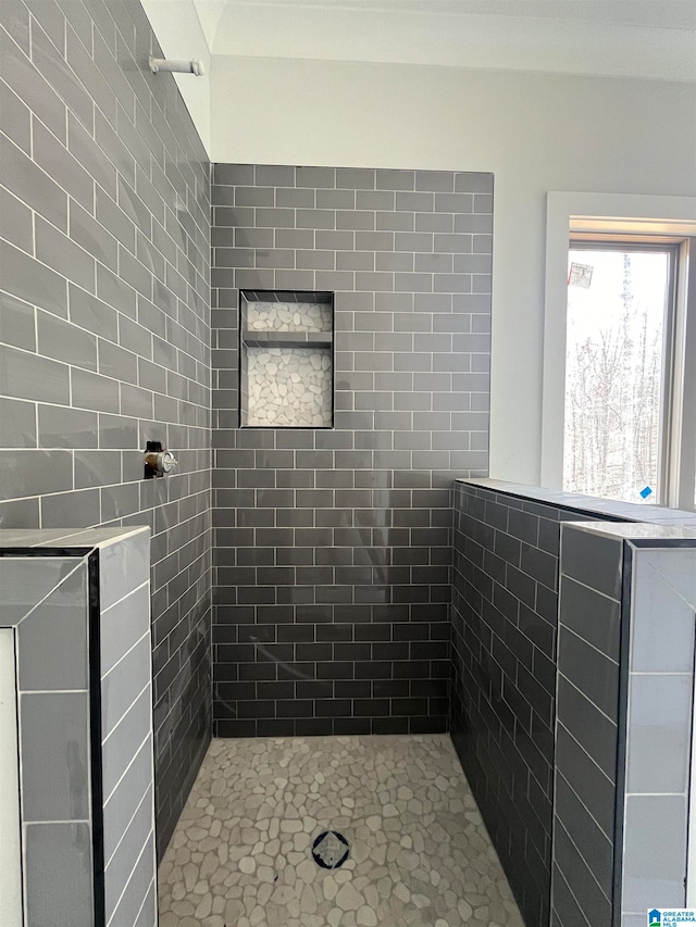 bathroom featuring a tile shower and tile walls