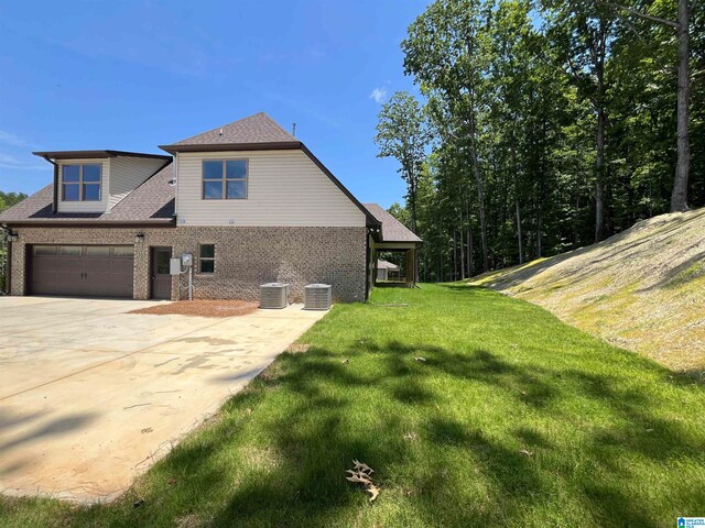 view of property exterior featuring a garage, central AC unit, and a lawn