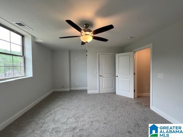 unfurnished bedroom featuring ceiling fan and carpet