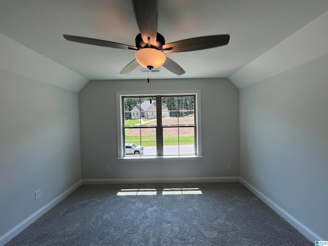 additional living space with dark colored carpet, ceiling fan, and lofted ceiling