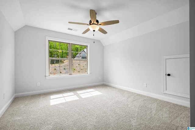 spare room featuring carpet flooring, visible vents, ceiling fan, and lofted ceiling