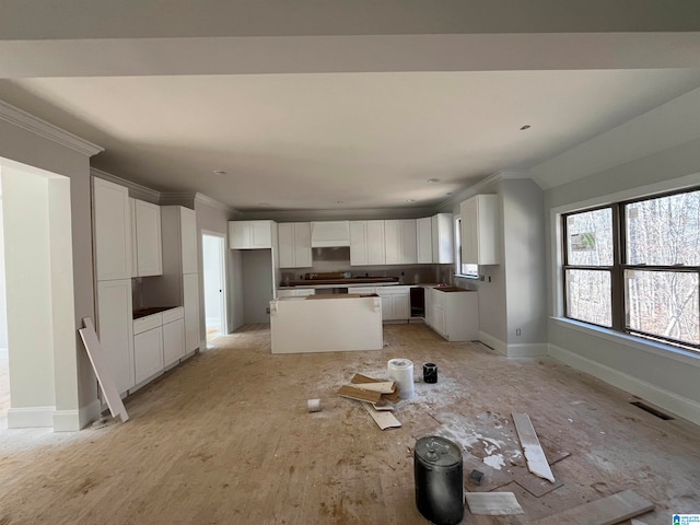 kitchen featuring light wood-type flooring, a kitchen island, white cabinetry, and ornamental molding