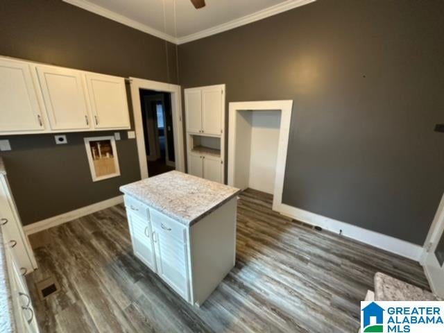 kitchen featuring white cabinets, a kitchen island, dark hardwood / wood-style floors, ceiling fan, and ornamental molding