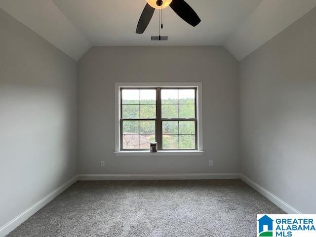 unfurnished room featuring carpet, vaulted ceiling, and ceiling fan