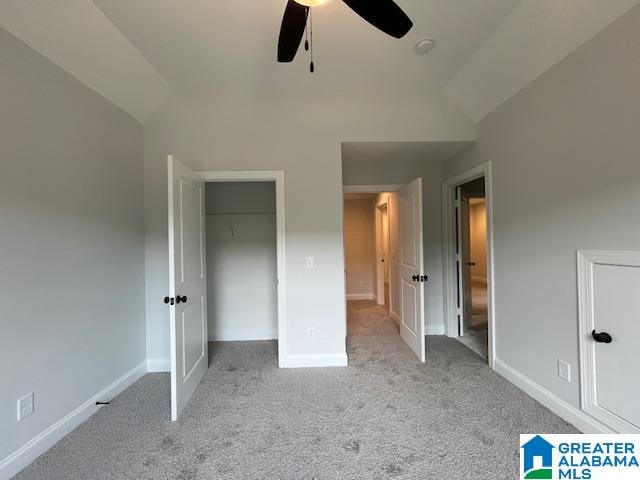 unfurnished bedroom with ceiling fan, lofted ceiling, light carpet, and a closet