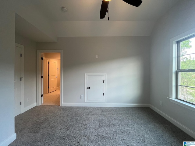 carpeted empty room featuring ceiling fan and lofted ceiling