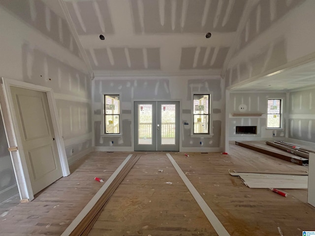 miscellaneous room featuring french doors, wood-type flooring, and lofted ceiling