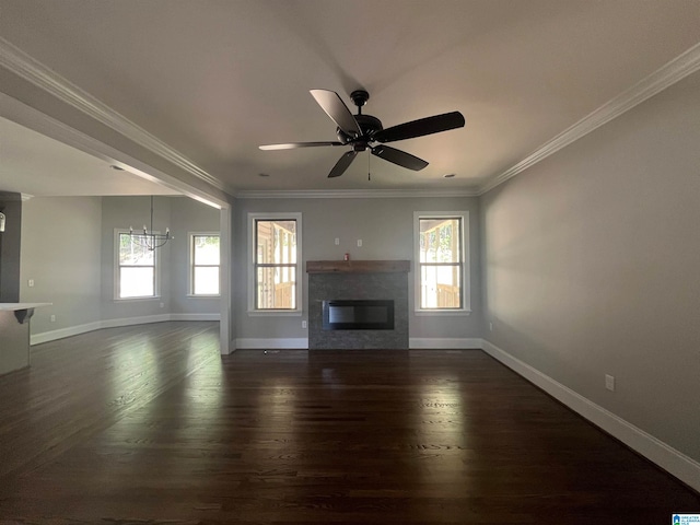 unfurnished living room featuring dark hardwood / wood-style flooring, a healthy amount of sunlight, and ceiling fan with notable chandelier