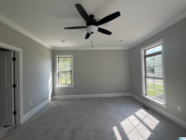 unfurnished room featuring plenty of natural light, ornamental molding, and ceiling fan