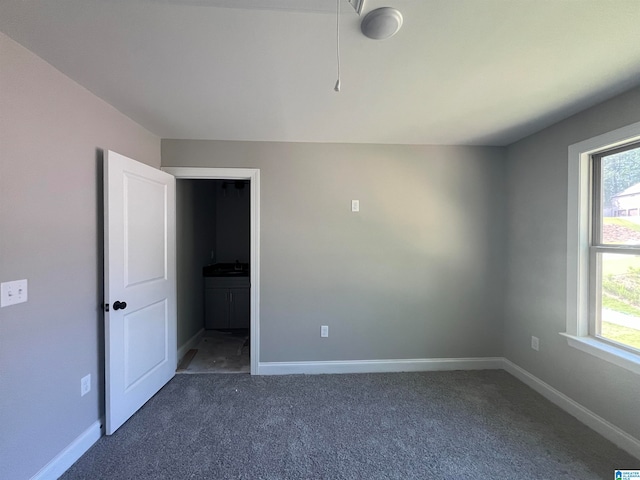 unfurnished room featuring dark colored carpet