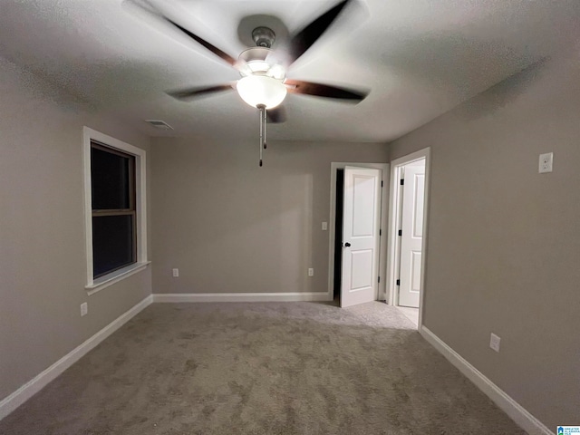 carpeted spare room with ceiling fan and a textured ceiling