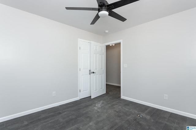 empty room featuring dark hardwood / wood-style flooring and ceiling fan