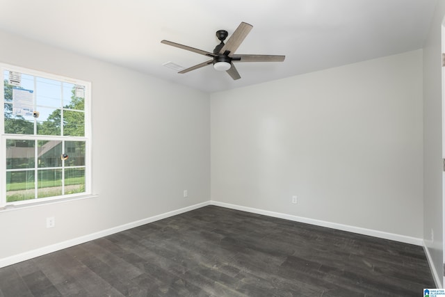 spare room featuring dark wood-type flooring, ceiling fan, and a healthy amount of sunlight