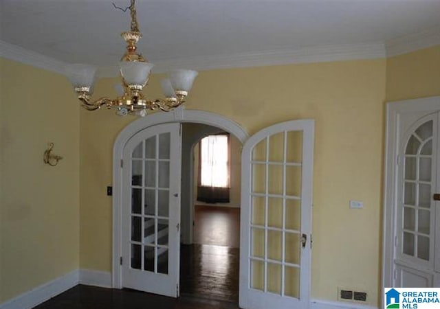 interior space with crown molding, french doors, a notable chandelier, and dark wood-type flooring