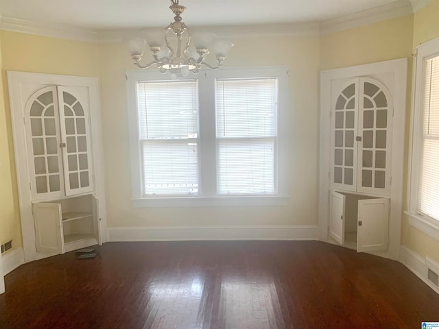 unfurnished dining area with dark hardwood / wood-style flooring, ornamental molding, and a chandelier