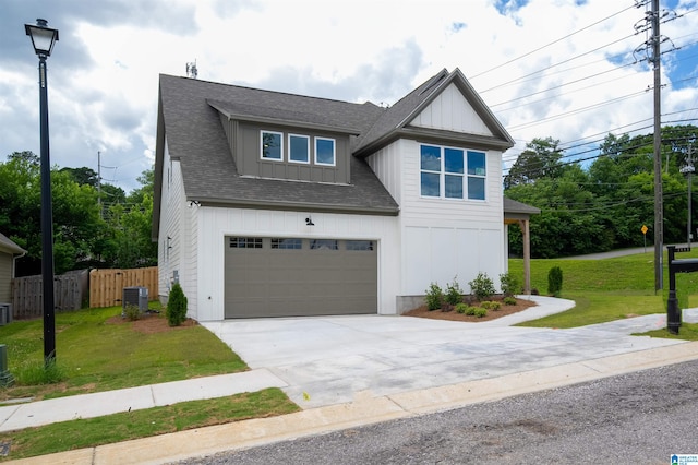 craftsman inspired home featuring cooling unit, a garage, and a front lawn