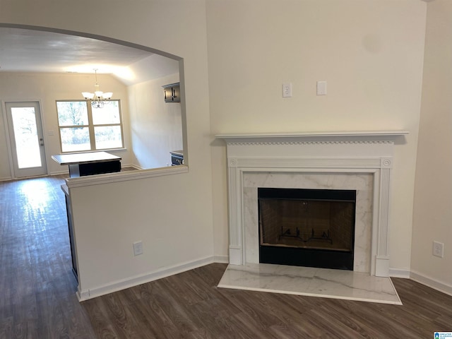 interior details with a high end fireplace, hardwood / wood-style flooring, and an inviting chandelier