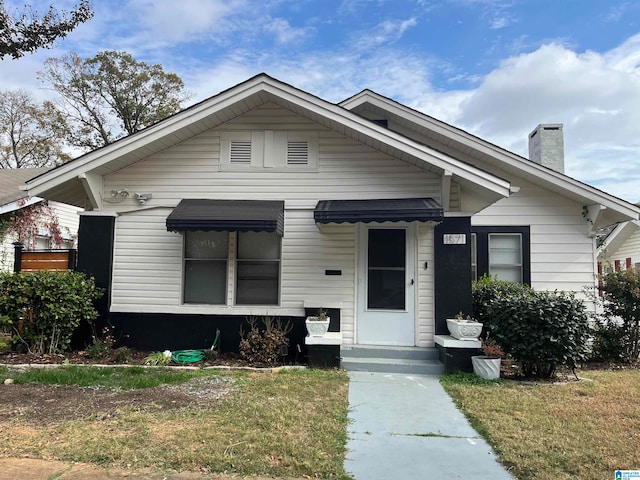 bungalow featuring a front lawn