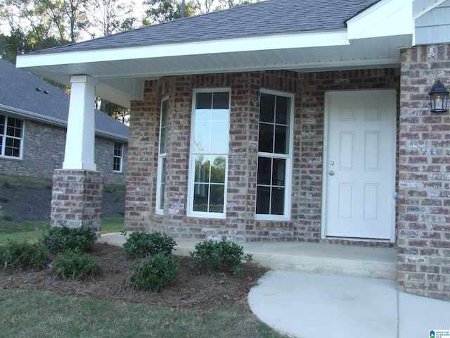 view of exterior entry featuring covered porch