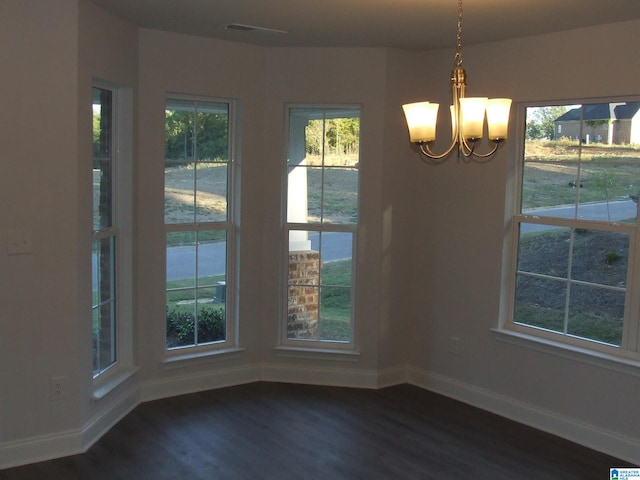 unfurnished dining area with dark hardwood / wood-style floors and a chandelier