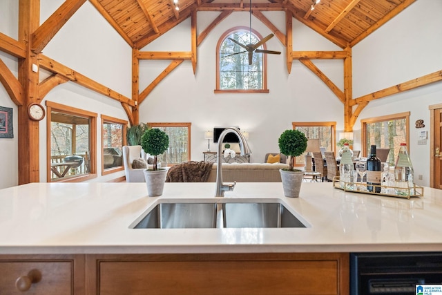 kitchen featuring wooden ceiling, high vaulted ceiling, sink, and beamed ceiling